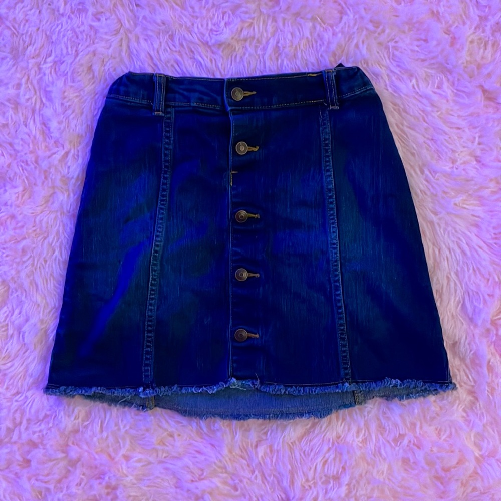 Snap buttoned jean skirt. Frayed at the bottom.